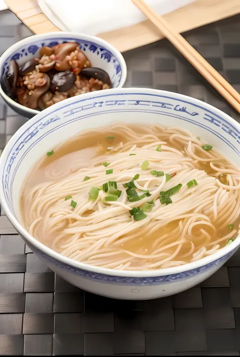 A large bowl of noodles, sprinkled with chopped green onion, a small bowl of mushroom meat, on a bamboo table