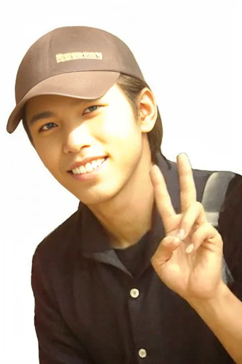 A person wearing a brown hat and black suit, Holding a peace sign. The background is a white circle with red text. "Yong Bunyong" At the deepest part, A cheerful and relaxed atmosphere.