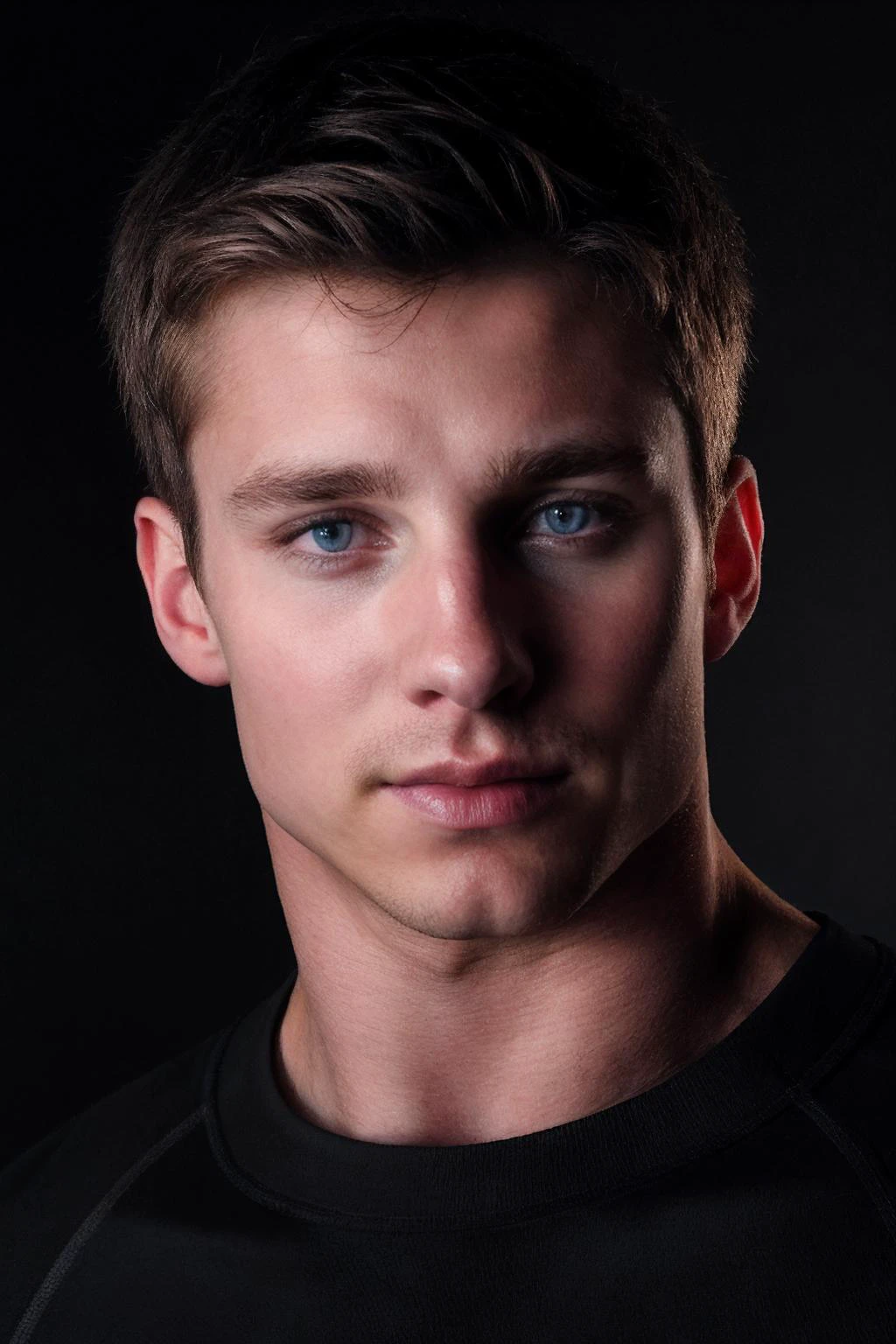 closeup photo of tyson_dayley wearing a fitted black compression shirt, plain matte black backdrop, soft directional lighting, even lighting, intense powerful mood