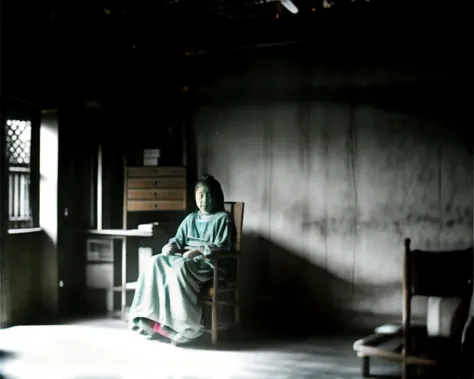 there is a woman sitting in a chair in a dark room