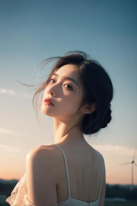 a woman in a white dress standing in front of a windmill