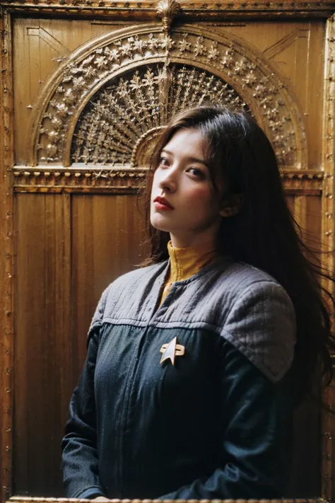 arafed woman in a blue jacket and yellow shirt standing in front of a wooden wall