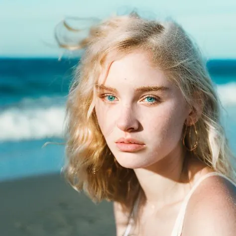 blond woman with blue eyes on the beach looking at the camera